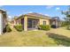 Home exterior featuring a screened-in patio, manicured lawn, and lush landscaping at 3640 Solana Cir # A, Clermont, FL 34711