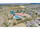 Aerial of a community featuring a clubhouse, pool, tennis courts, and manicured grounds at 3640 Solana Cir # A, Clermont, FL 34711