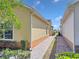 View of the side of the home with a brick walkway, green landscaping, and neutral color palette at 3640 Solana Cir # A, Clermont, FL 34711
