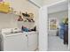 Functional laundry room with washer, dryer, storage shelves, and natural light from adjacent room at 3640 Solana Cir # A, Clermont, FL 34711
