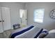 Well-lit bedroom with stylish bedding, a bench, and a view into an ensuite bath at 3708 Merryweather Dr, Orlando, FL 32812