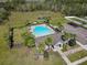 Aerial view showcasing community amenities: a pool, playground, parking and a well-maintained clubhouse with lush landscaping at 3861 Hanworth Loop, Sanford, FL 32773