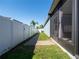 Fenced backyard with a brick pathway alongside screened-in patio for added privacy at 3861 Hanworth Loop, Sanford, FL 32773