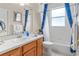 Bathroom with wood cabinets, a vanity, and a shower/tub combo with blue accents at 460 Quail Hill Dr, Debary, FL 32713