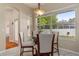 Bright dining room with a glass-top table, white chairs, and view of the landscaped backyard at 460 Quail Hill Dr, Debary, FL 32713