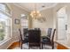 Cozy dining room with chandelier, glass table and dark leather chairs at 460 Quail Hill Dr, Debary, FL 32713