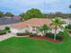 Aerial view of charming single-story home with beautiful landscaping, a two car garage, and manicured lawn at 460 Quail Hill Dr, Debary, FL 32713