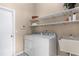 Efficient laundry room featuring shelving, utility sink, washer, and dryer for convenience at 460 Quail Hill Dr, Debary, FL 32713