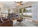 Comfortable living room featuring a reclining leather sofa, ceiling fan, and sliding door to patio at 460 Quail Hill Dr, Debary, FL 32713