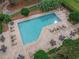 Aerial view of a spacious community pool surrounded by lounge chairs, tables and lush landscaping for a relaxing ambiance at 460 Quail Hill Dr, Debary, FL 32713