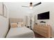 Cozy bedroom featuring wood floors, a ceiling fan, and a dresser with a television at 4713 Capri Pl # 190, Orlando, FL 32811