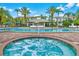 Enjoy the community pool with a jacuzzi featuring nearby seating and lush palms at 5000 Cayview Ave # 10108, Orlando, FL 32819