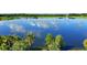 Scenic water view featuring a serene lake reflecting the sky, framed by lush greenery and palm trees at 5000 Cayview Ave # 10108, Orlando, FL 32819