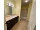 Bathroom with dark vanity, a large mirror, a shower with glass doors and tile flooring at 5105 City St # 817, Orlando, FL 32839