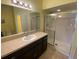 Bathroom with dark vanity, a large mirror, a shower with glass doors, and tile flooring at 5105 City St # 817, Orlando, FL 32839