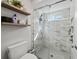 Modern bathroom featuring a glass-enclosed shower and floating shelves for storage at 5140 Honeynut Ln, Windermere, FL 34786