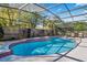 Beautiful in-ground pool surrounded by screen enclosure, patio, plants, and fence at 5140 Honeynut Ln, Windermere, FL 34786