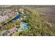 An aerial view shows tennis courts alongside a canal winding through a residential area and natural landscape at 520 Longmeadow St, Celebration, FL 34747