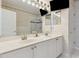 Bathroom with double sinks, white cabinets, a decorative mirror and television at 520 Longmeadow St, Celebration, FL 34747