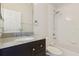 Bright bathroom featuring a granite vanity top, and a shower/tub combo with white tile at 520 Longmeadow St, Celebration, FL 34747