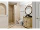 Inviting bathroom featuring a tiled shower and a decorative vanity with a round mirror at 520 Longmeadow St, Celebration, FL 34747