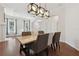 A dining room with an elegant light fixture hanging above a wooden table and a living area visible in the background at 520 Longmeadow St, Celebration, FL 34747