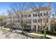 Charming three-story townhome with black shutters, a green front door, and mature trees in a neighborhood setting at 520 Longmeadow St, Celebration, FL 34747