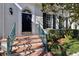 Elegant front entrance with brick steps, teal handrails, and a black front door with brass accents at 520 Longmeadow St, Celebration, FL 34747