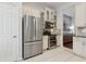 Kitchen features a stainless steel refrigerator and oven, and white cabinets with glass door inserts at 520 Longmeadow St, Celebration, FL 34747