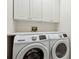 Functional laundry room with white washer and dryer and built in cabinets and folding space at 520 Longmeadow St, Celebration, FL 34747