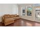 Bright living room featuring hardwood floors, a comfortable brown leather sofa and large windows at 520 Longmeadow St, Celebration, FL 34747