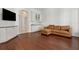 Cozy living room featuring hardwood floors, a wet bar, and a comfortable brown leather sofa at 520 Longmeadow St, Celebration, FL 34747