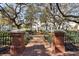 Red brick entrance to tranquil park featuring fountain, benches, and lush landscaping, offering a serene outdoor retreat at 520 Longmeadow St, Celebration, FL 34747