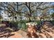 Brick-paved walkway with a decorative metal fence that highlights beautiful landscaping and mature trees in this neighborhood park at 520 Longmeadow St, Celebration, FL 34747