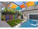 This backyard features a pool, colorful shades, turf, privacy screen, and stylish decor at 520 Longmeadow St, Celebration, FL 34747