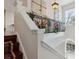 Staircase landing featuring white rails with floral decor, an ornate light fixture, and bright, arched windows at 520 Longmeadow St, Celebration, FL 34747