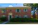 Charming brick condo featuring a front door beneath an archway, complemented by green shutters and lush landscaping at 524 Georgetown Dr # A, Casselberry, FL 32707