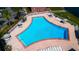 Aerial view of the community pool with lounge chairs, umbrellas, and a brick surround at 524 Georgetown Dr # A, Casselberry, FL 32707