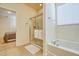 Bright bathroom featuring a glass enclosed shower, soaking tub and a view into the adjacent bedroom at 6090 Broad Oak Dr, Davenport, FL 33837