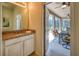 Powder room with granite countertop and access to the screened patio with an outdoor table and ceiling fans at 6090 Broad Oak Dr, Davenport, FL 33837