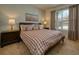 Bright bedroom featuring a comfortable bed with a stylish brown and white checked pattern and natural light from the window at 6090 Broad Oak Dr, Davenport, FL 33837