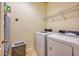 Functional laundry room with modern washer and dryer, wire shelf and ironing board at 6090 Broad Oak Dr, Davenport, FL 33837