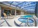 Private screened pool area with hot tub, sun loungers, and outdoor dining space at 6090 Broad Oak Dr, Davenport, FL 33837