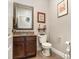 Cozy half-bathroom featuring a granite countertop, dark wood cabinets, and decorative wall art at 6346 Dallas Blvd, Orlando, FL 32833