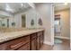 Bathroom with wood cabinetry, granite counters, and a large mirror at 6346 Dallas Blvd, Orlando, FL 32833