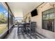 View of the covered patio with outdoor furniture, a television, and a view of the backyard at 6346 Dallas Blvd, Orlando, FL 32833