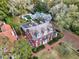 Aerial view of red brick home with black shutters, landscaped lawn, pool, and brick driveway at 721 Delaney Ave, Orlando, FL 32801