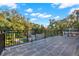 Expansive balcony with wrought iron railing overlooking a lush backyard and mature trees at 721 Delaney Ave, Orlando, FL 32801