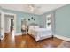 Charming bedroom features hardwood floors, a decorative ceiling fan, and soothing, light-blue wall paint at 721 Delaney Ave, Orlando, FL 32801