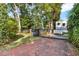 Brick driveway leading to an ornate iron gate with manicured lawn and lush landscaping at 721 Delaney Ave, Orlando, FL 32801